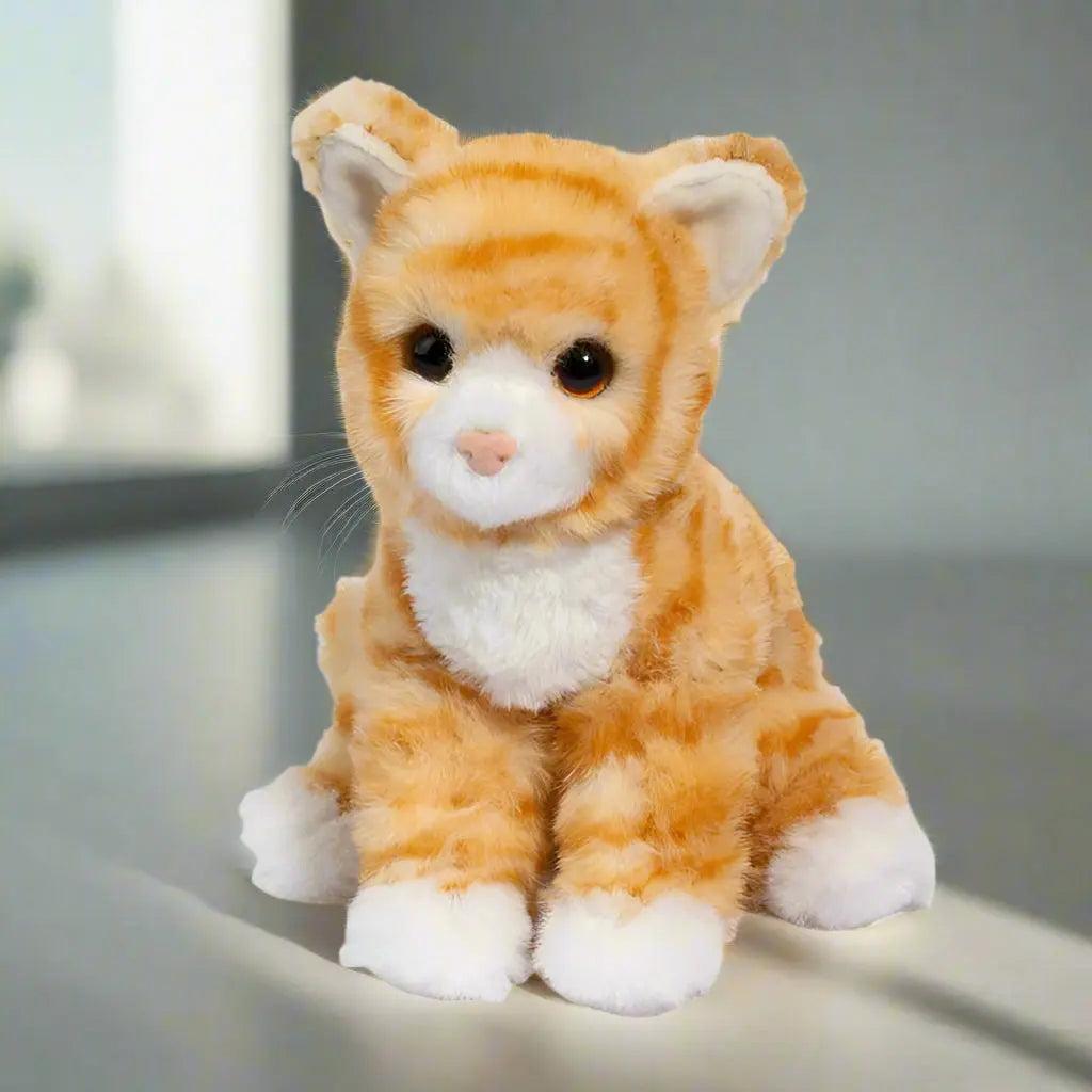 Plush toy cat with orange and white fur on a white background