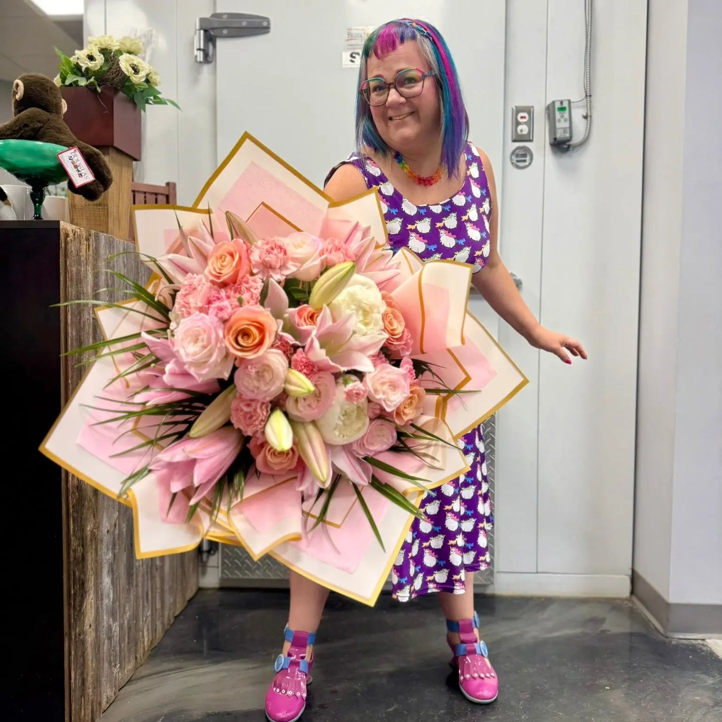 Person holding a large bouquet of flowers in an indoor setting