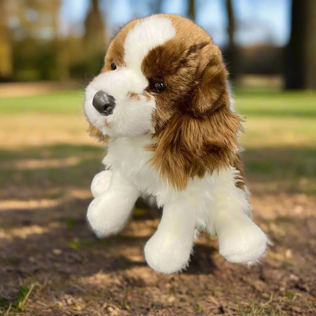 A plush toy resembling a Springer Spaniel dog with a liver and white coat, detailed feathering on the legs, and long-haired ear details.