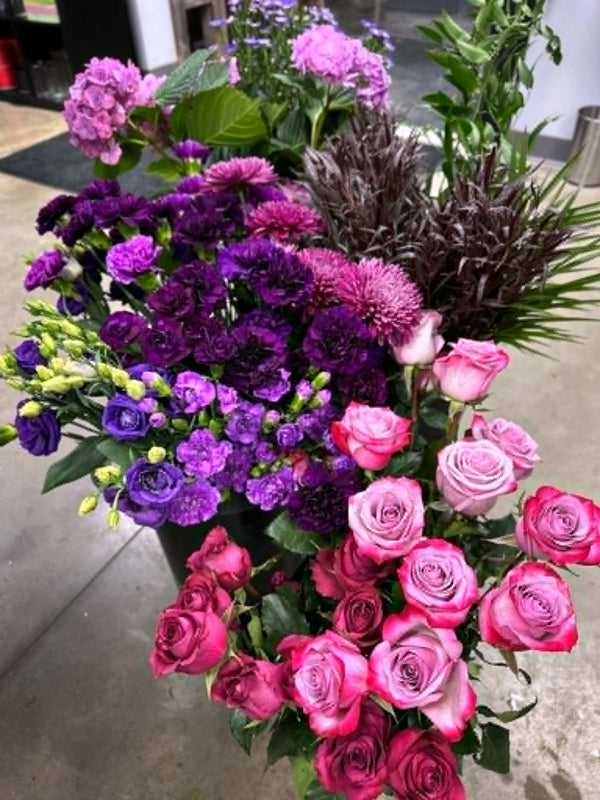 mixed pink, purple, and lavender flowers prepped before creating a wedding bouquet