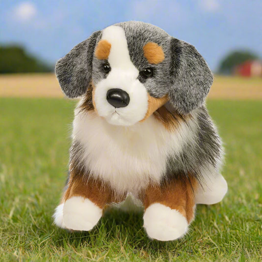 Plush toy dog with brown, black, and white fur on a white background