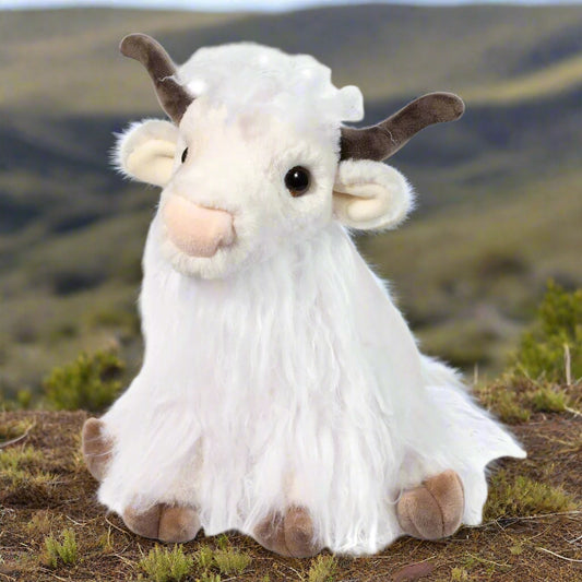Plush toy goat with white fur and brown accents on a white background