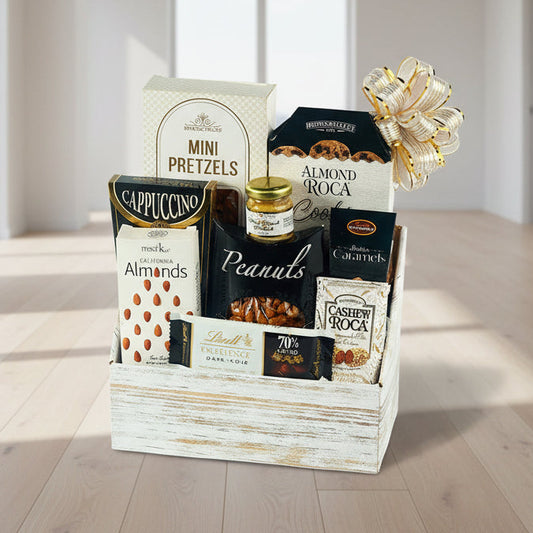 Gift basket with assorted snacks and treats in a wooden box on a white background