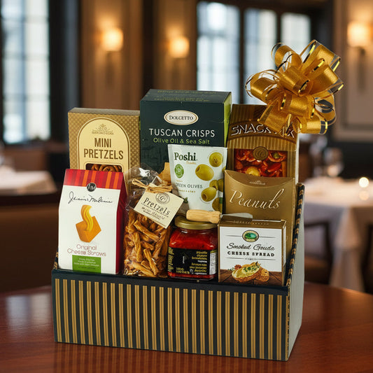 Gourmet gift basket with various snacks and a gold bow on a white background