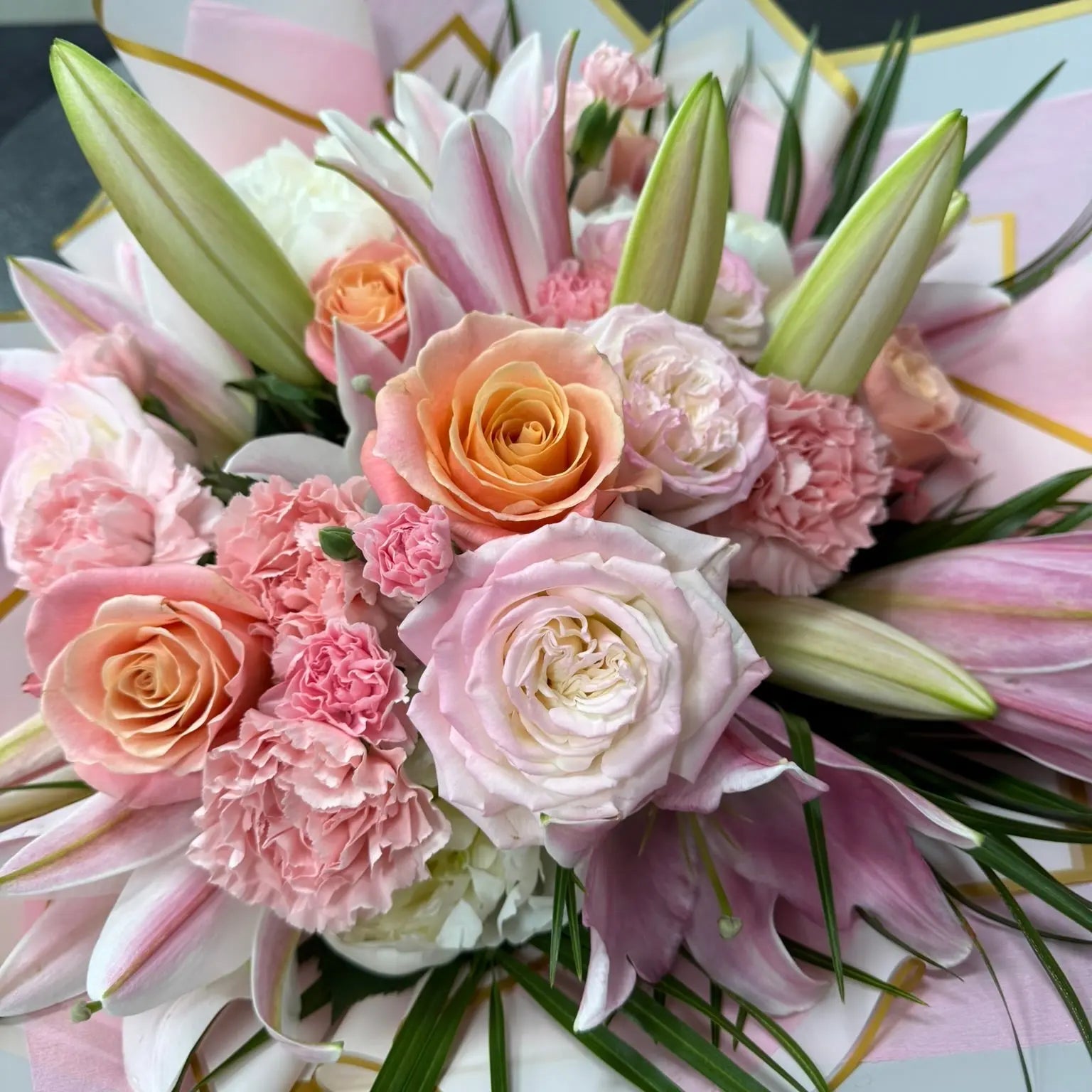 Bouquet of pink and white flowers with decorative paper in the background