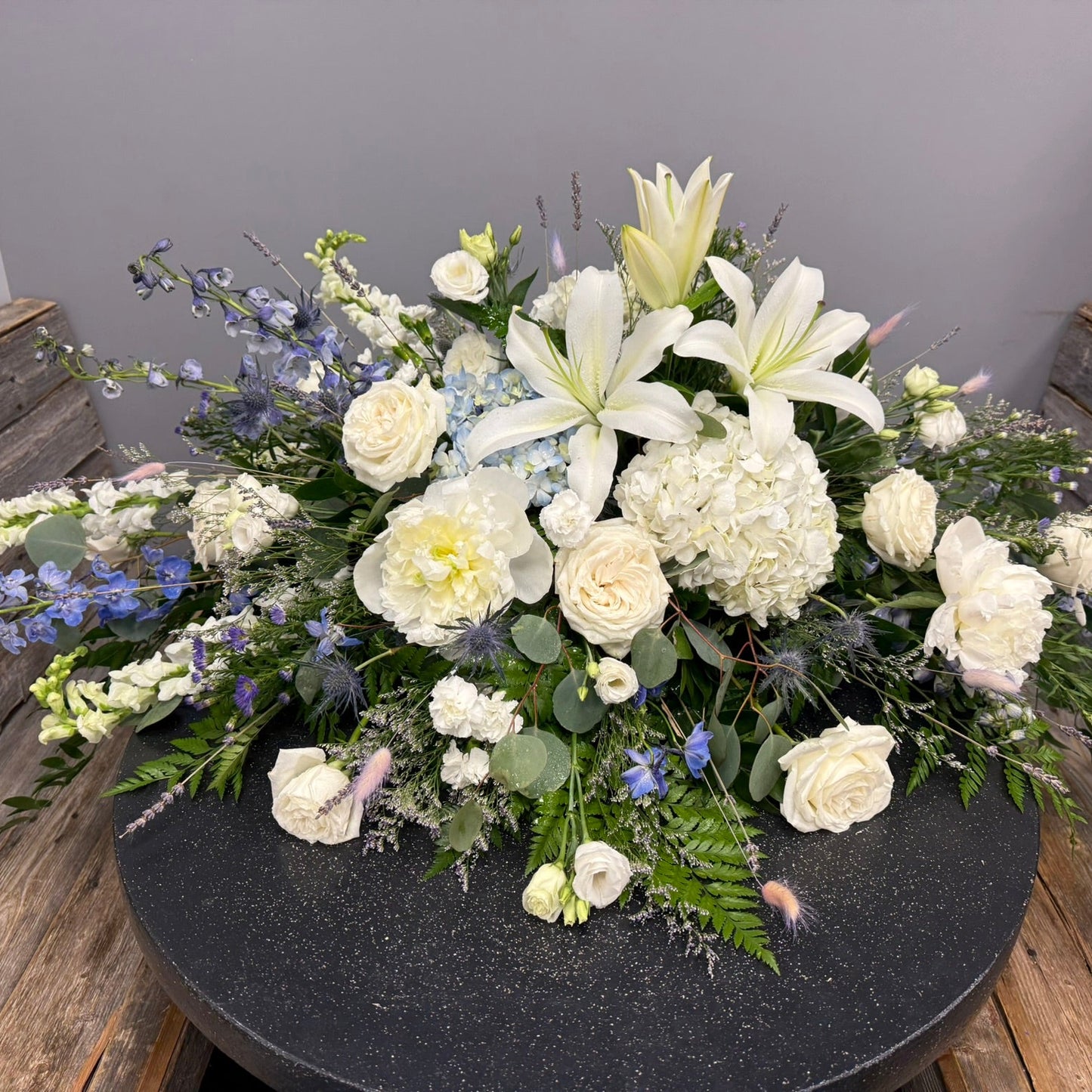 Floral arrangement with white and green flowers on a dark surface.