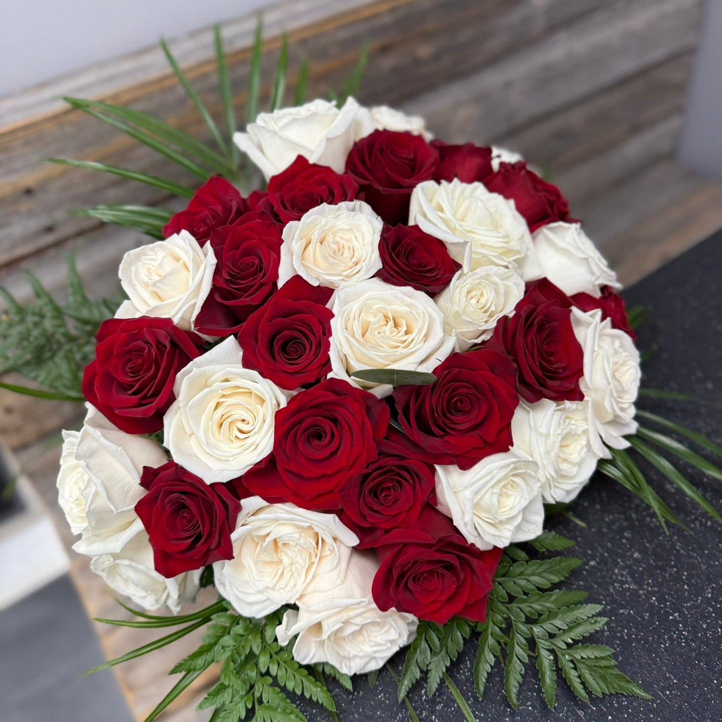 Bouquet of red and white roses on a wooden surface