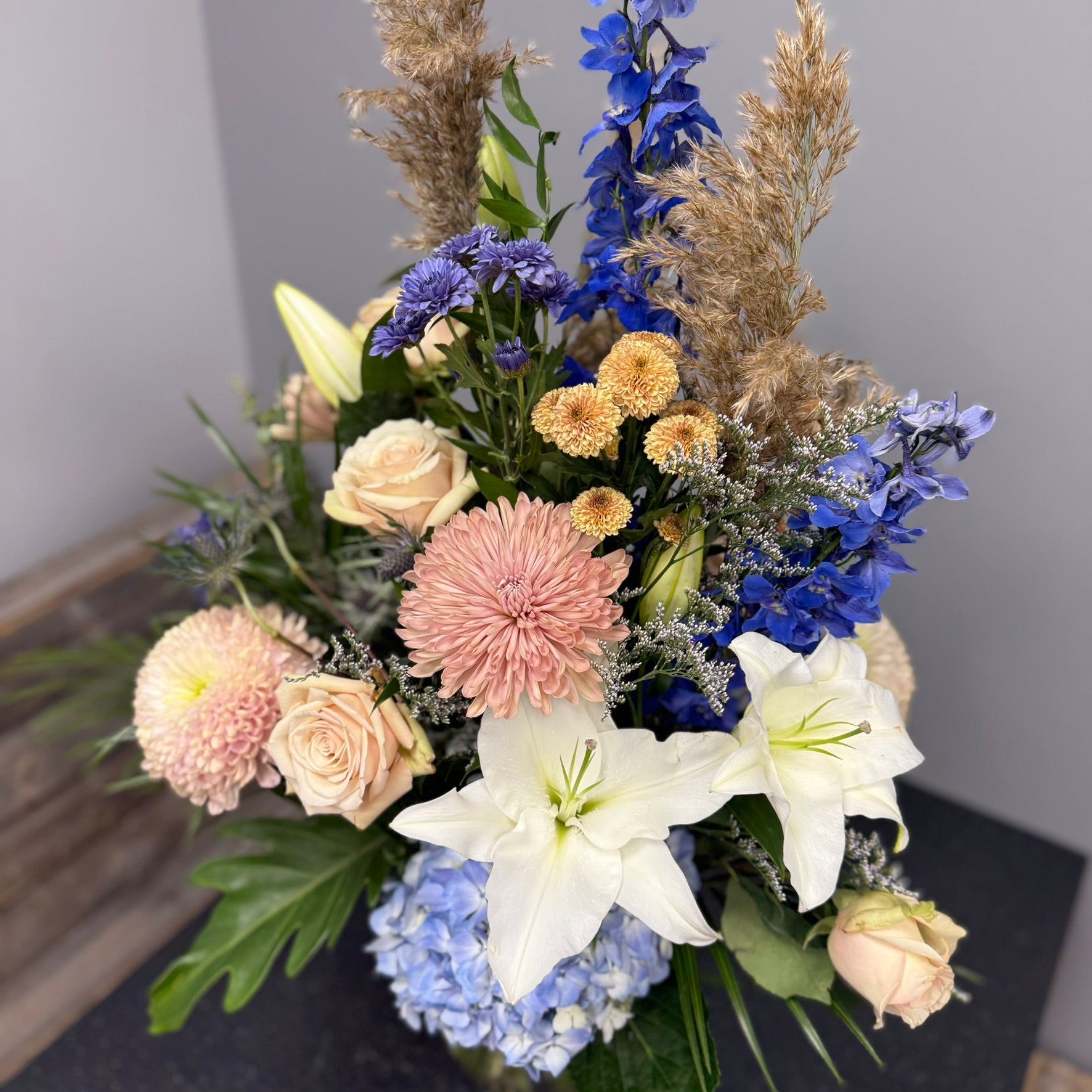 Bouquet of flowers with blue, pink, and white colors on a neutral background